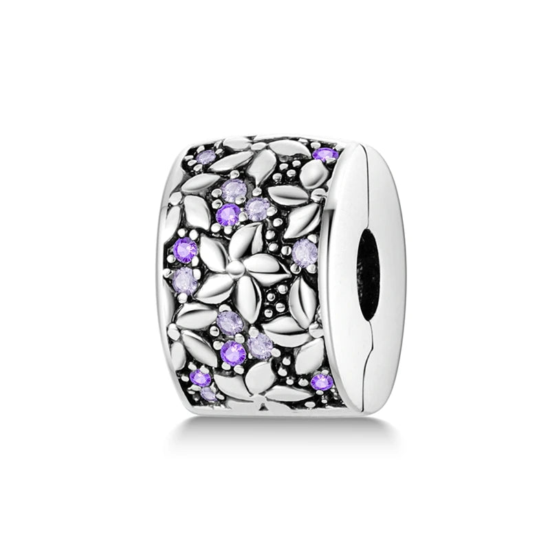 Silver charm with purple stones on a white background