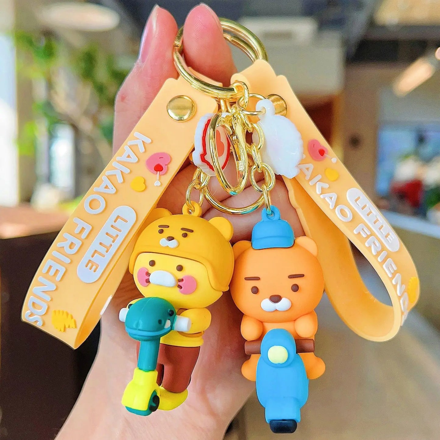 Keychain with cartoon characters and 'Kakao Friends' branding held by a hand.
