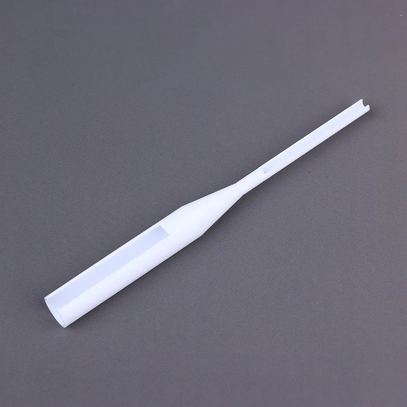 A white plastic dropper pipette with a clear viewing window, shown diagonally on a dark gray background.