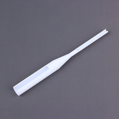 A white plastic dropper pipette with a clear viewing window, shown diagonally on a dark gray background.