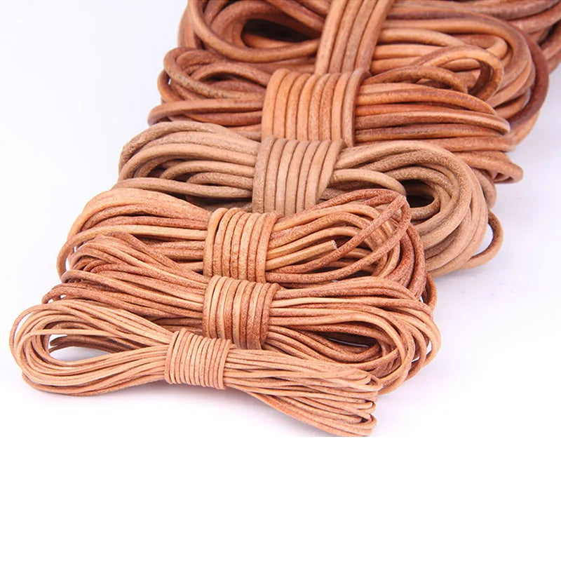 Multiple coiled strands of tan and light brown leather cord or shoelace, bundled in small groups, photographed on a clean white background.