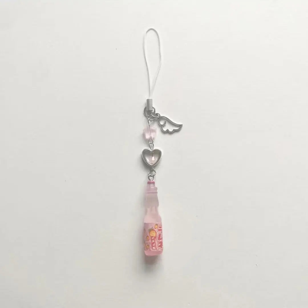 Phone charm with pink pendant and heart-shaped tag on a white background