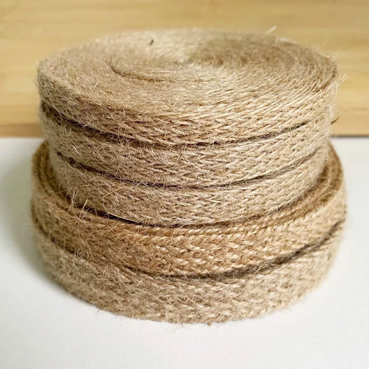 Stack of brown jute twine on a white surface with a wooden background