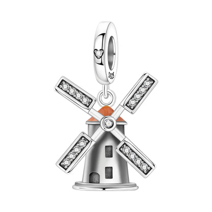 Silver windmill charm with orange roof and clear stones on a white background