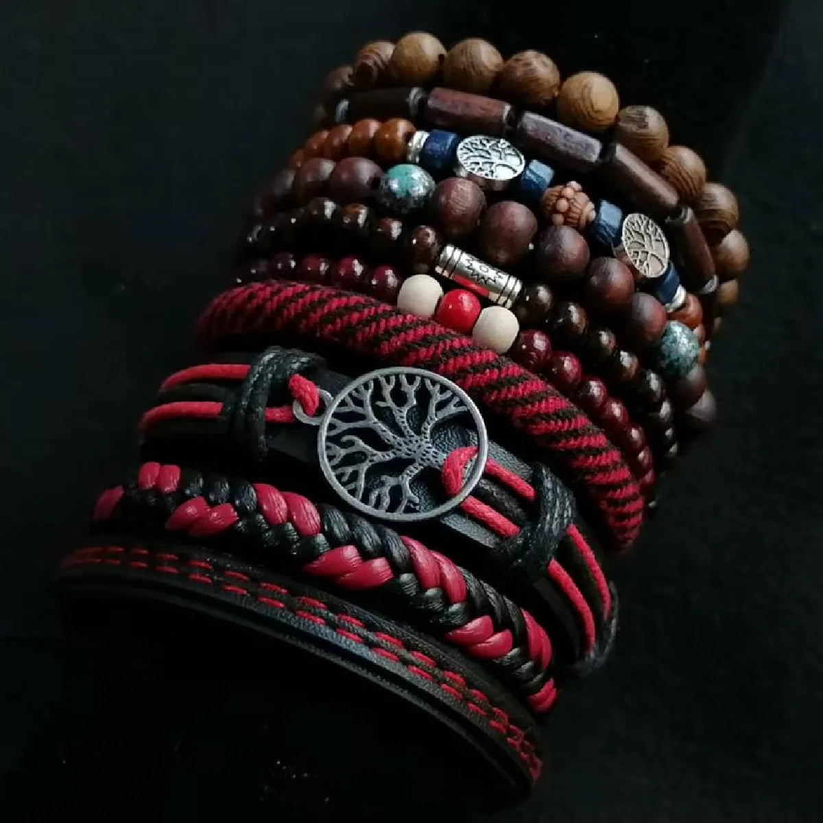 Stack of bracelets with tree-of-life design on a dark background