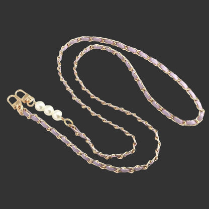 Gold chain with purple beads and a pearl on a white background