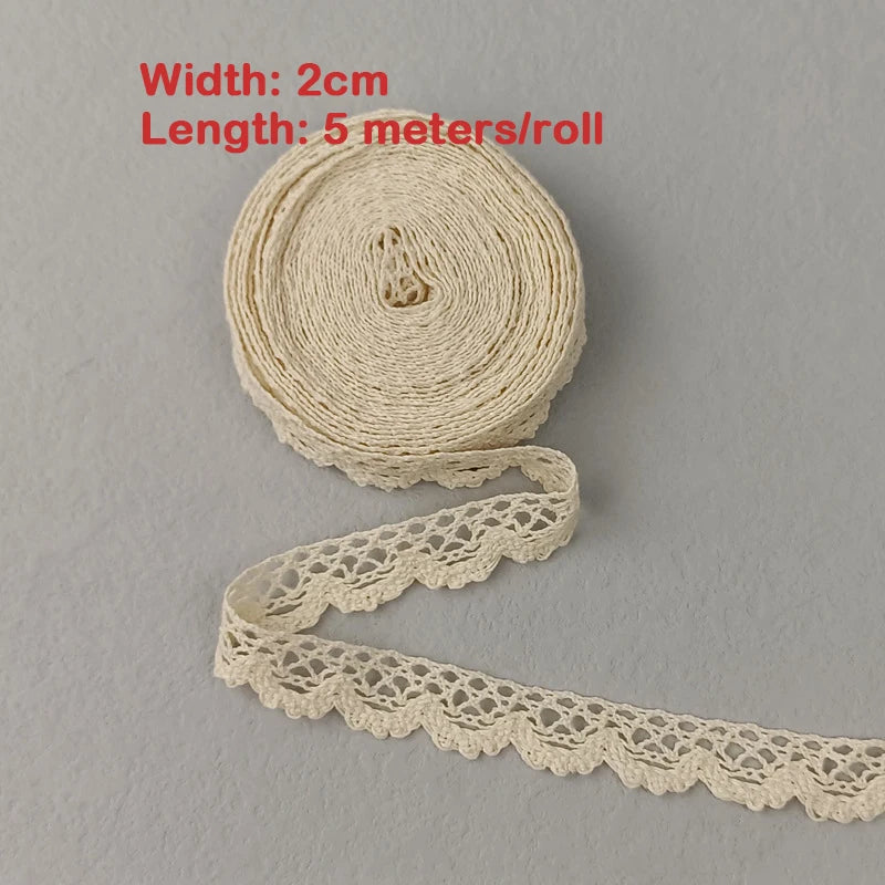 Roll of beige lace trim with measurements on a gray background