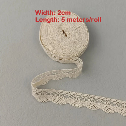 Roll of beige lace ribbon with text indicating width and length on a gray background