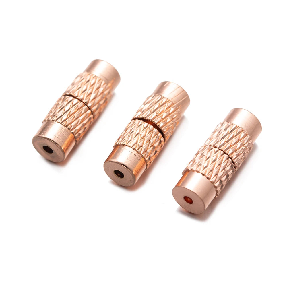 Three rose gold cylindrical metal jewelry connectors on a white background