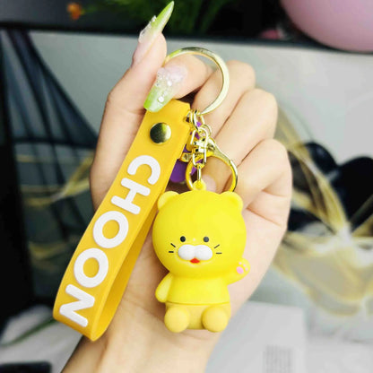 Yellow keychain with a cartoon character held by a hand