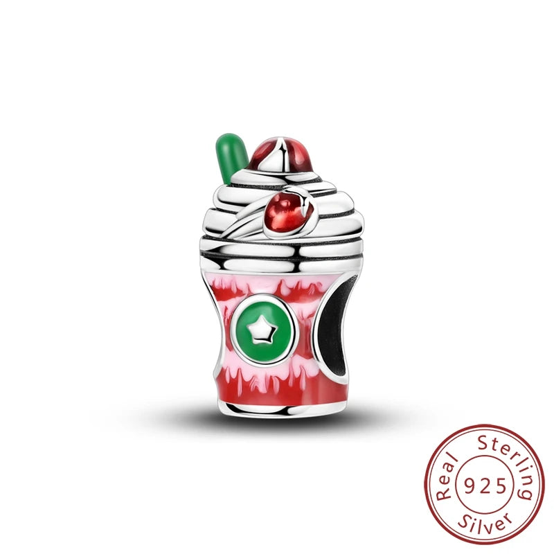 A sterling silver charm shaped like a whipped cream dessert cup, featuring red and green enamel details, a green star emblem on the front, and a 'Real Sterling Silver 925' seal in the bottom right corner.
