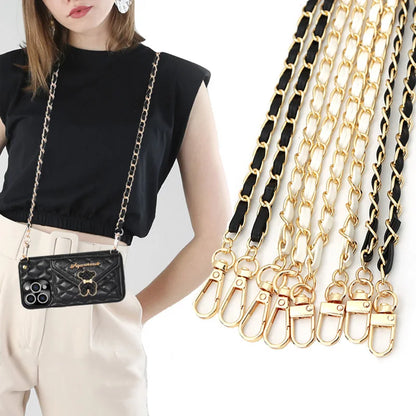 Woman wearing a black handbag with a gold chain strap, surrounded by various gold chain straps.