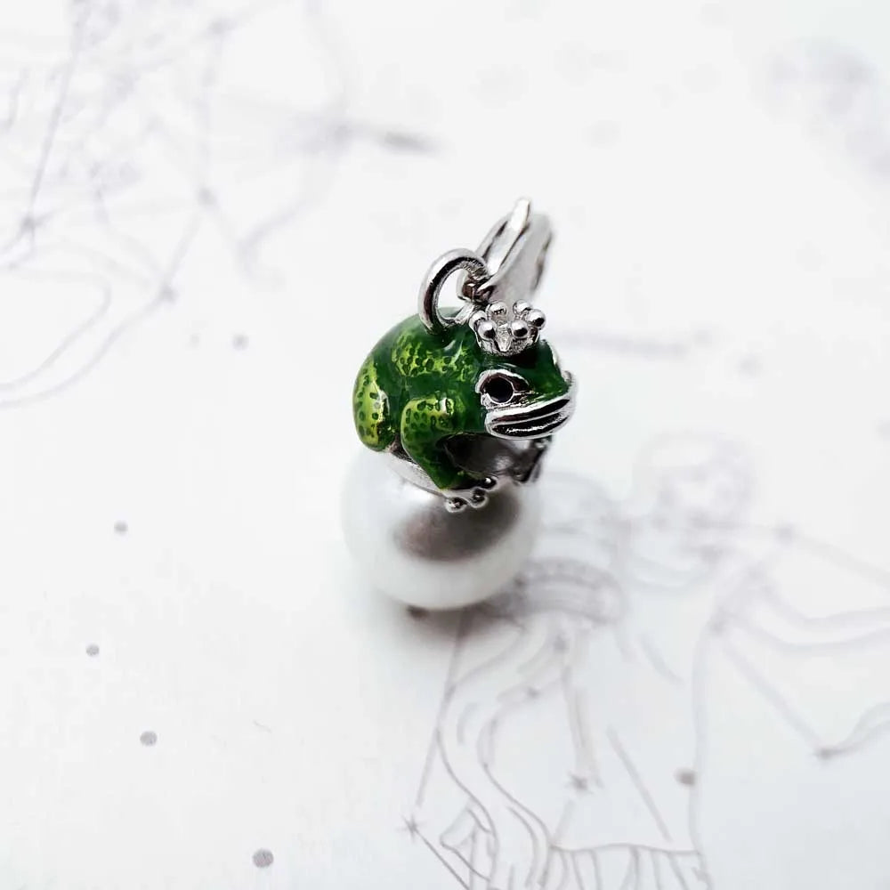 Green and silver frog charm on a white background