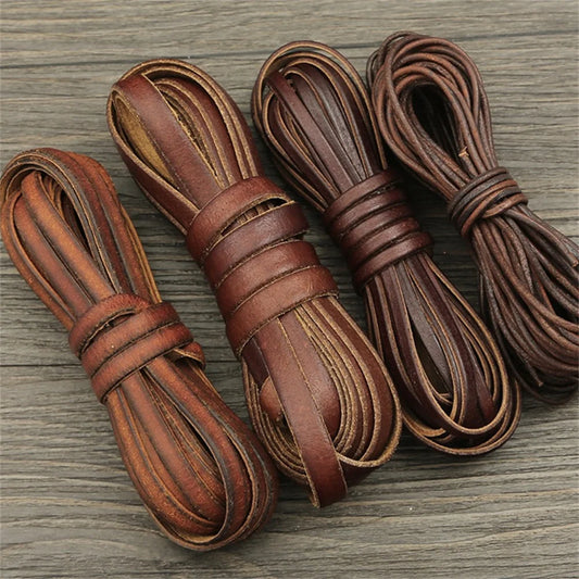 Four bundles of brown leather cord on a wooden surface