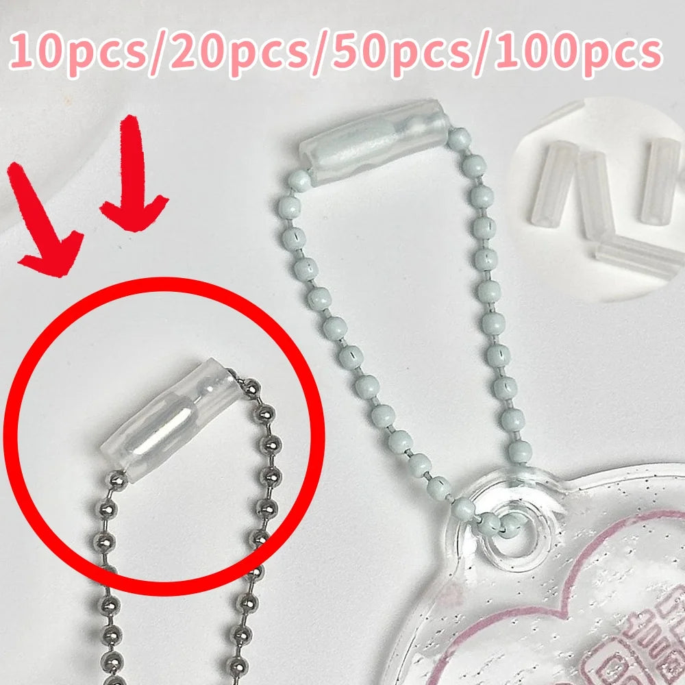 Clear plastic bead ball chain accessory with a silver ball chain and a translucent heart-shaped charm, shown on a white background with red arrows and text indicating quantity options.