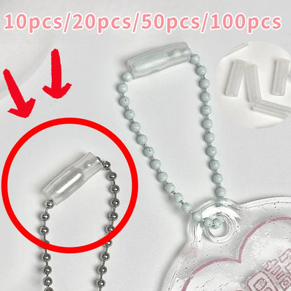 Clear plastic bead ball chain accessory with a silver ball chain and a translucent heart-shaped charm, shown on a white background with red arrows and text indicating quantity options.
