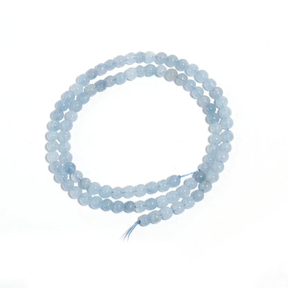 A double-strand beaded necklace made of light blue, semi-translucent round gemstone beads, coiled on a plain white background.