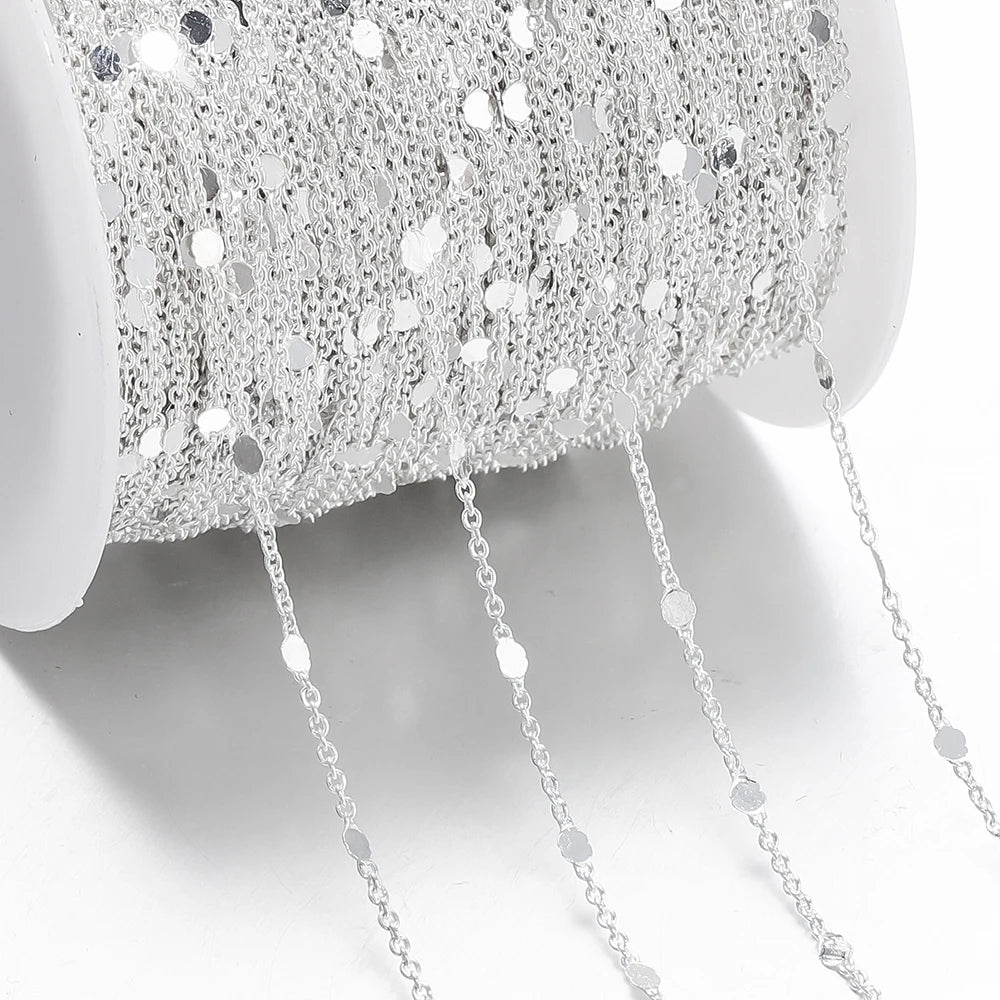Close-up of a silver chain with a textured silver bowl in the background