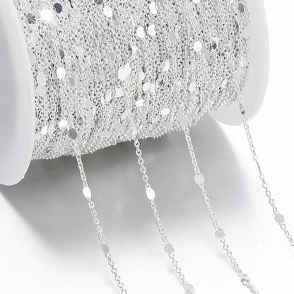 Close-up of a silver chain with a textured silver bowl in the background