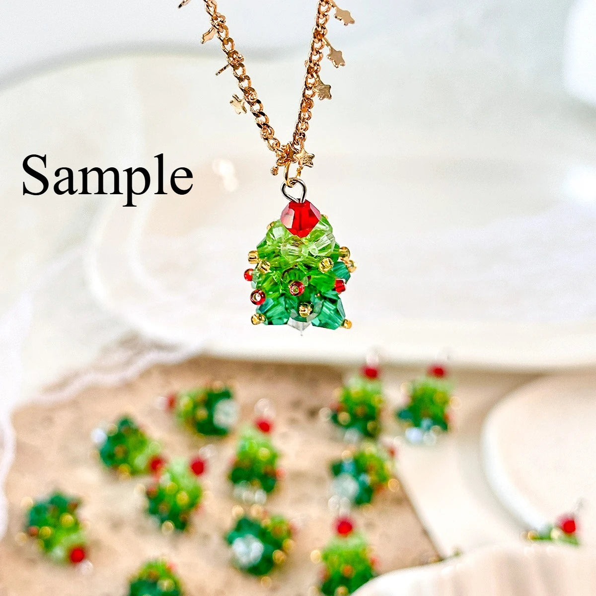 Christmas tree-shaped necklace with green beads and red accents on a white background