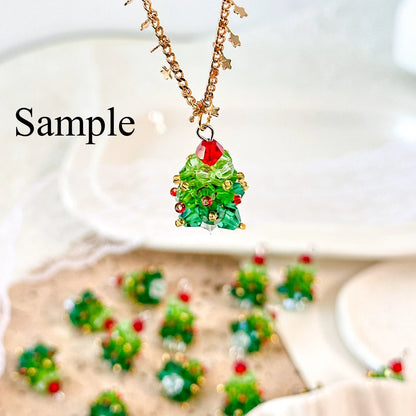Christmas tree-shaped necklace with green beads and red accents on a white background