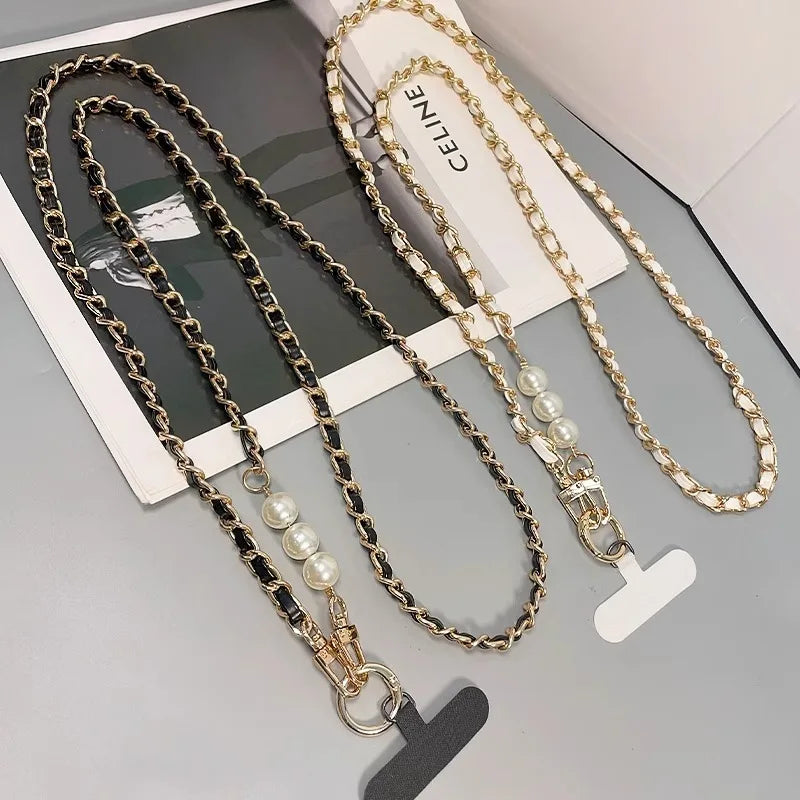 Two chain necklaces with pearl accents on a gray surface, one branded 'Celine'.