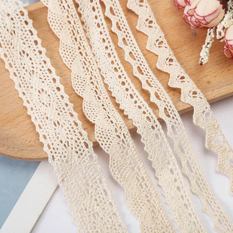 Beige lace fabric strips on a wooden board with flowers in the background