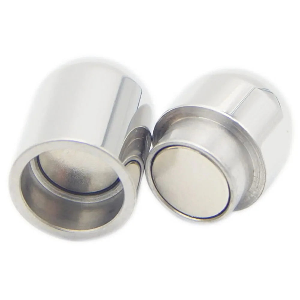 Two small cylindrical metallic magnetic caps with smooth, reflective silver surfaces, shown on a plain white background.