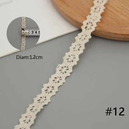 Lace trim with a close-up of a bracelet on a gray surface
