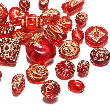 A collection of red translucent glass beads with various ornate gold foil patterns, scattered on a white background.
