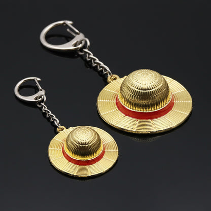 Gold hats with red bands keychain on a black background
