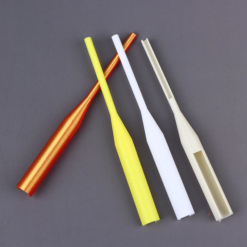 Four plastic fishing line guides in orange, yellow, white, and beige, arranged diagonally on a dark gray background.