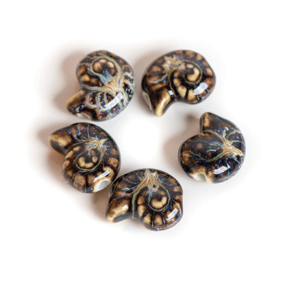 Five glossy spiral-shaped beads with a dark brown and black marbled pattern and cream veining, arranged in a circle on a white background.