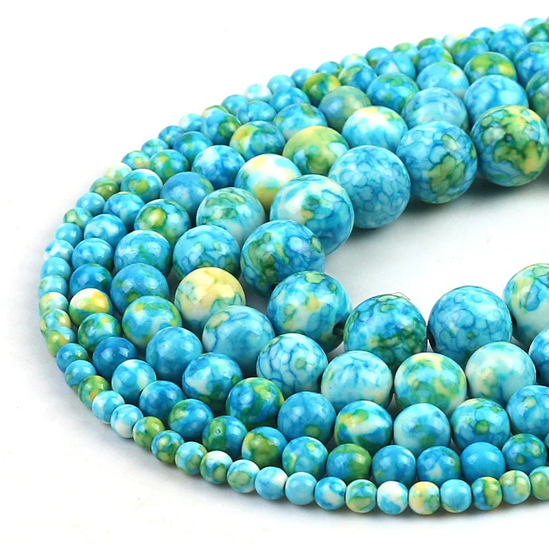 Round turquoise-blue and green marbled gemstone beads in multiple sizes, arranged in overlapping strands on a white background.
