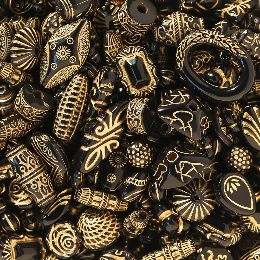 Close-up of a pile of black and gold beads with intricate patterns.