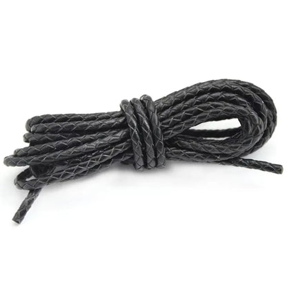 Black leather cord tied into a knot on a white background