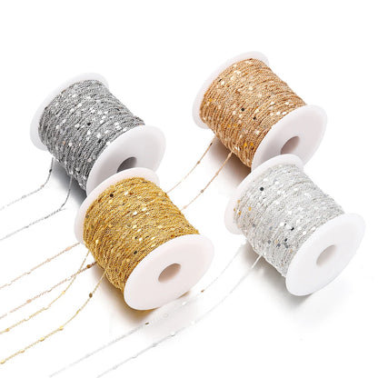 Four spools of glittery thread in gold, silver, and bronze on a white background