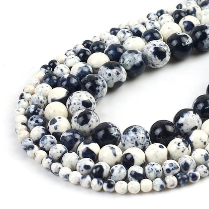 Multiple strands of round gemstone beads in large and small sizes, featuring a mottled pattern of dark navy blue, black, and off-white on a clean white background.