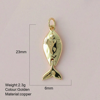Gold fish-shaped pendant with measurements and material details on a light gray background