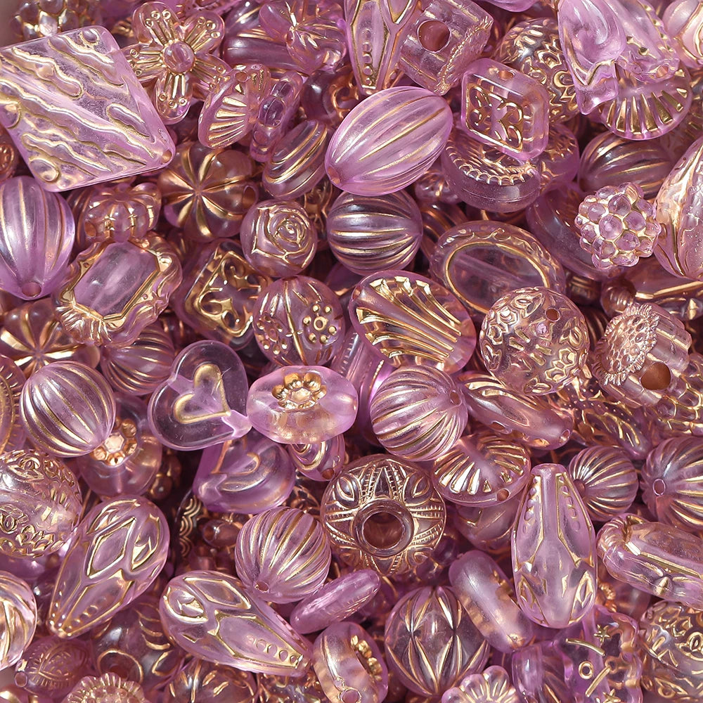 Assorted purple and gold beads with decorative patterns