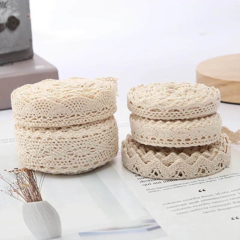 Two beige crochet containers on a white surface with a blurred background