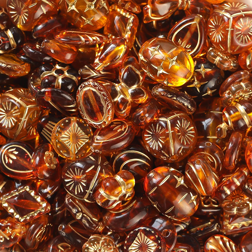 Close-up of amber-colored glass beads with floral patterns