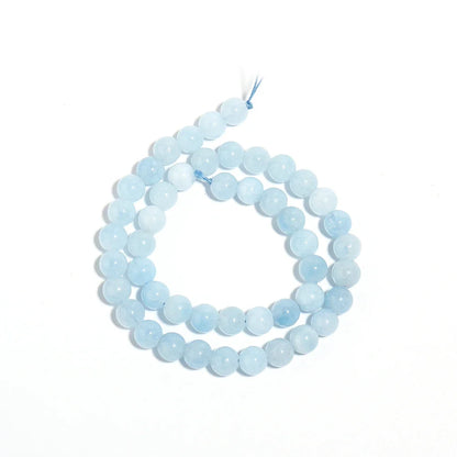 A strand of light blue round gemstone beads, likely amazonite, coiled on a plain white background.