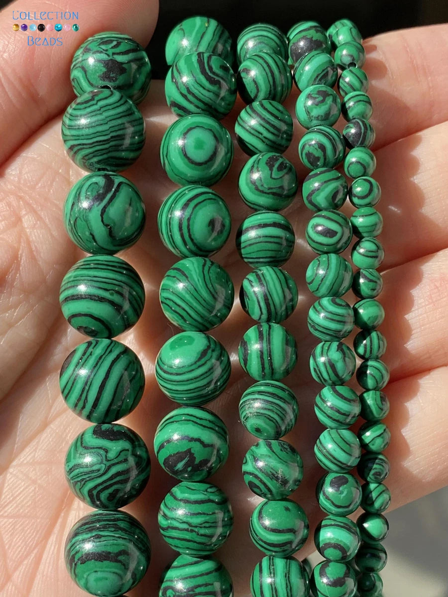 Five strands of green malachite bead bracelets in various sizes, held in a person's hand to show the details and texture of the beads.