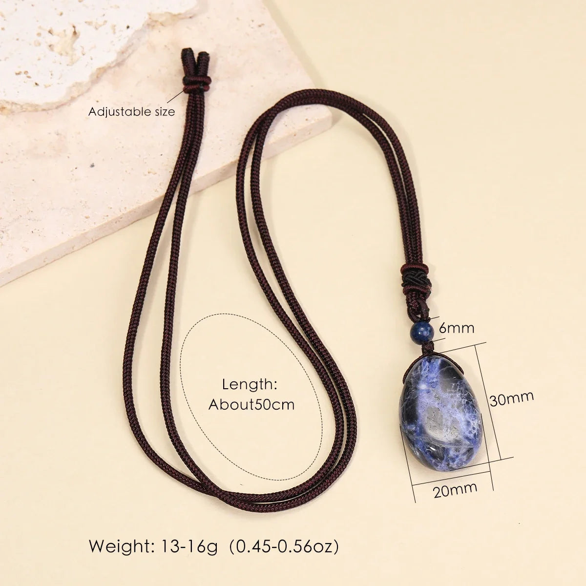 Necklace with a blue pendant on a beige background, showing measurements and weight details.