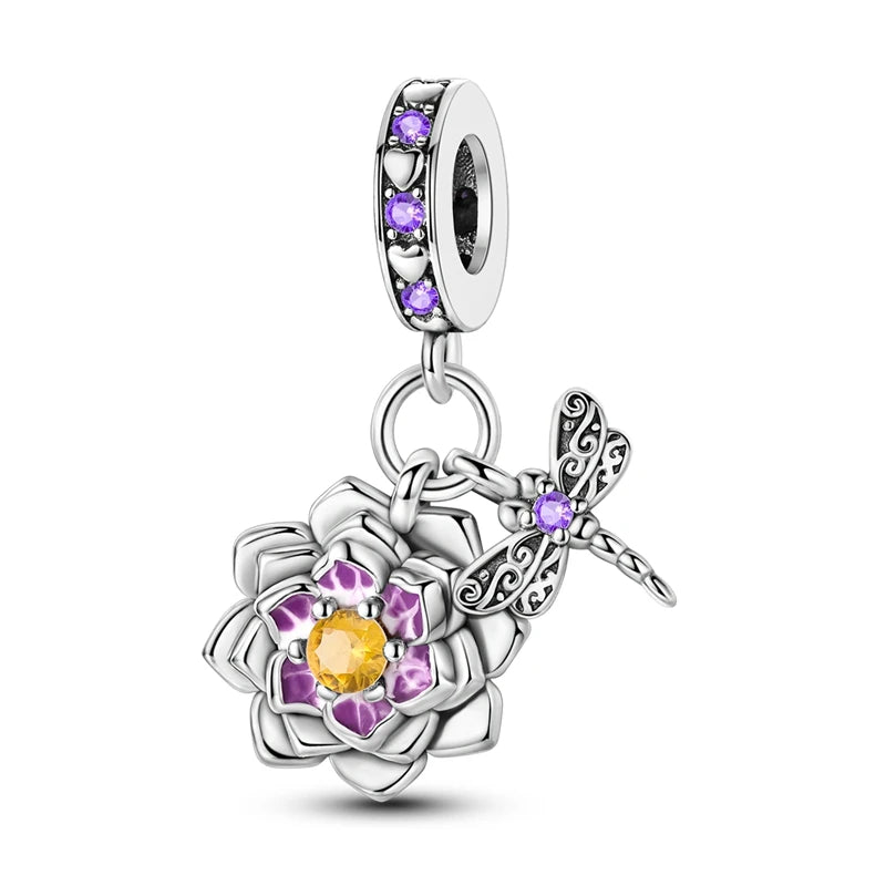 Silver charm with purple and yellow stones on a white background