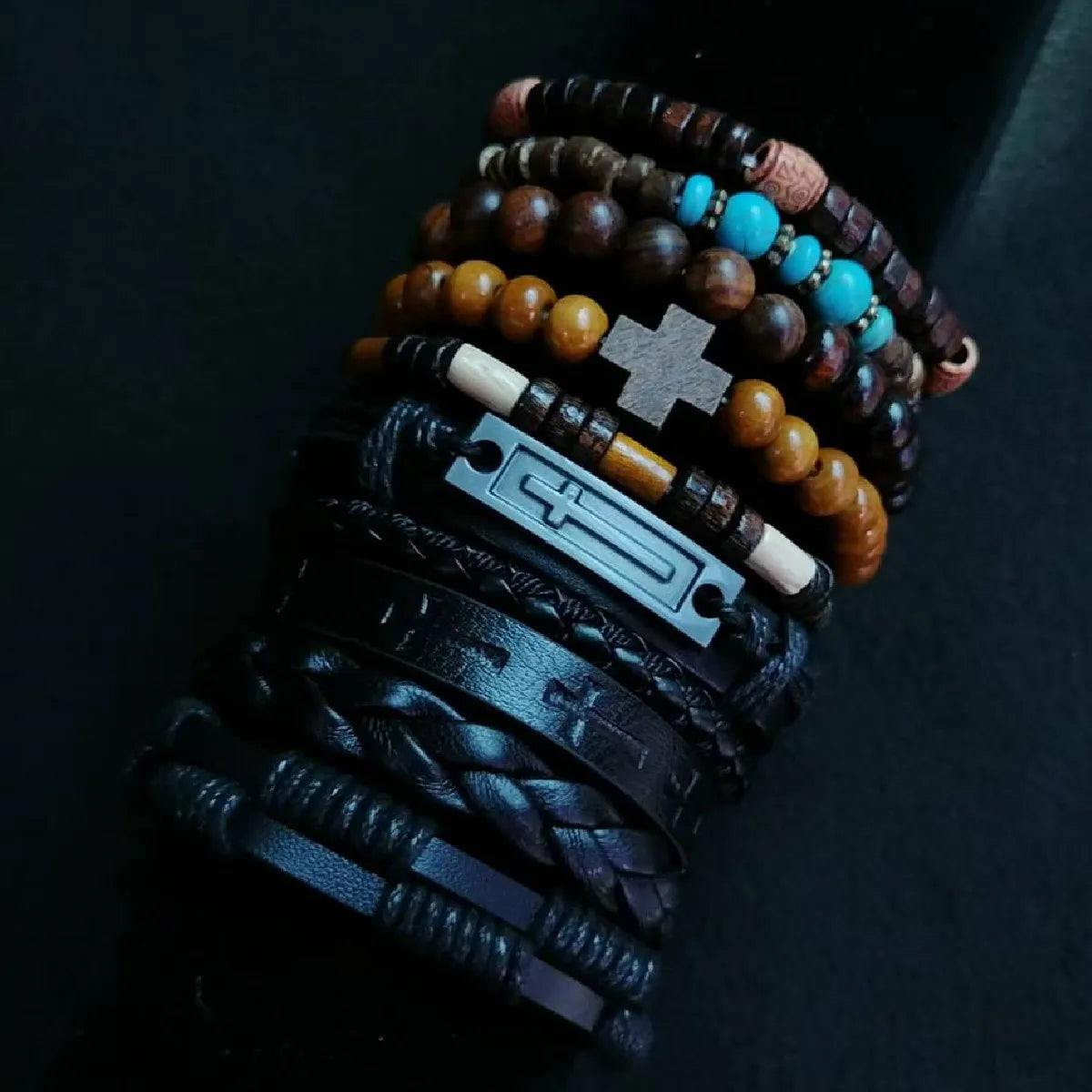 Stack of bracelets with beads and leather straps on a dark background