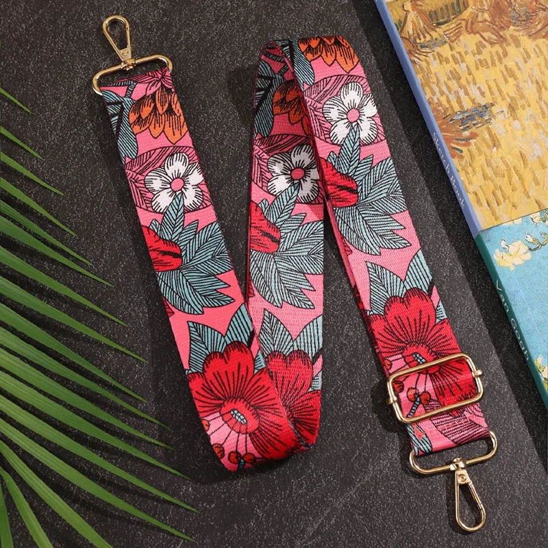 Floral patterned strap with gold hardware on a dark surface