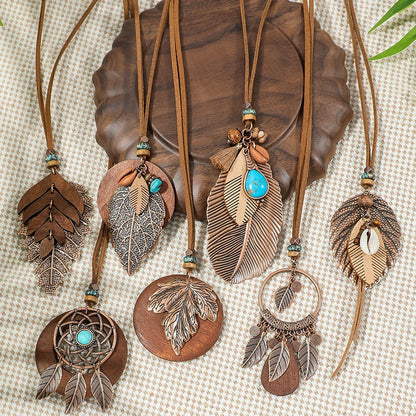 Collection of feather-themed necklaces on a textured surface