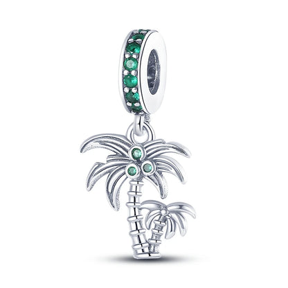 Silver palm tree charm with green gemstones on a white background